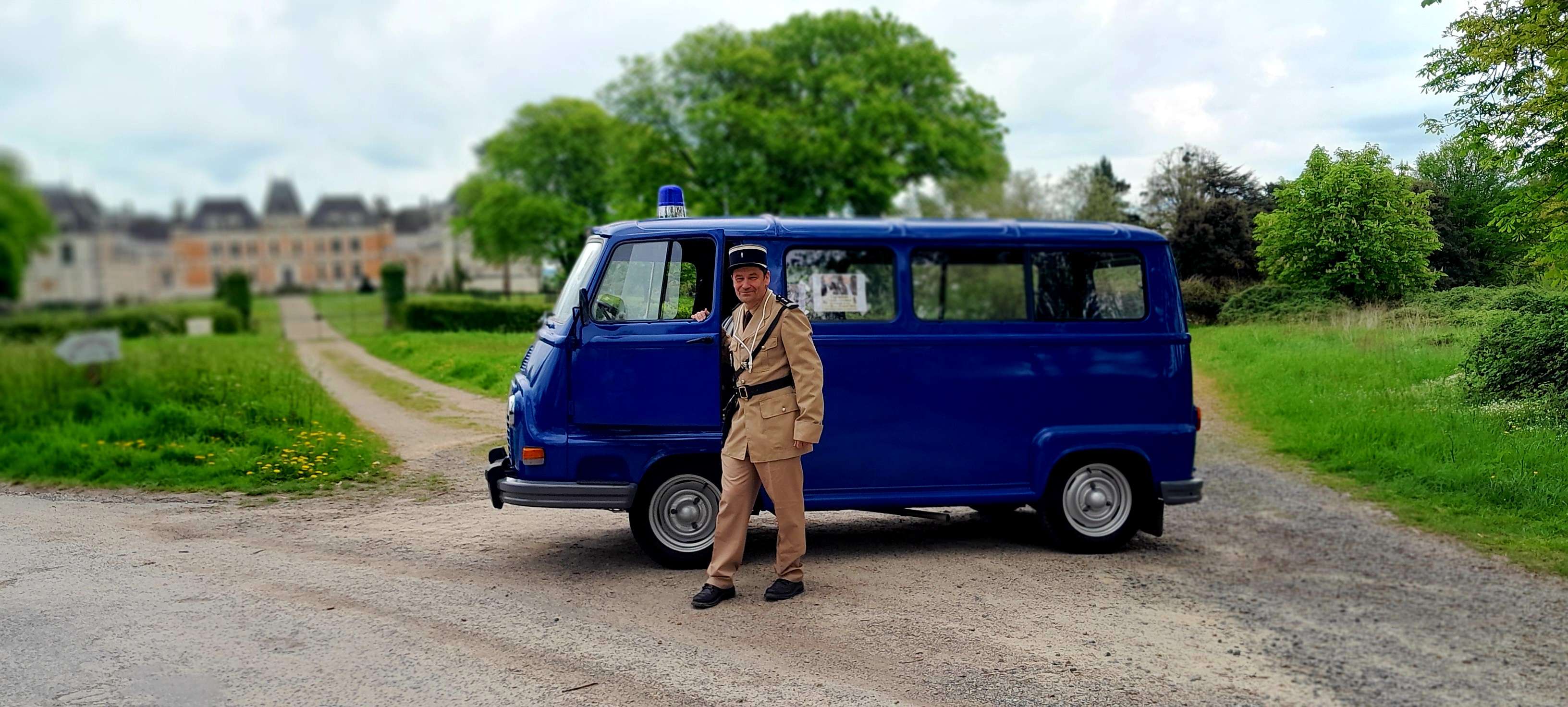 Photo de Didier Schleiss en tenue ancienne de gendarme, à côté d'une ancienne estafette de gendarmerie.